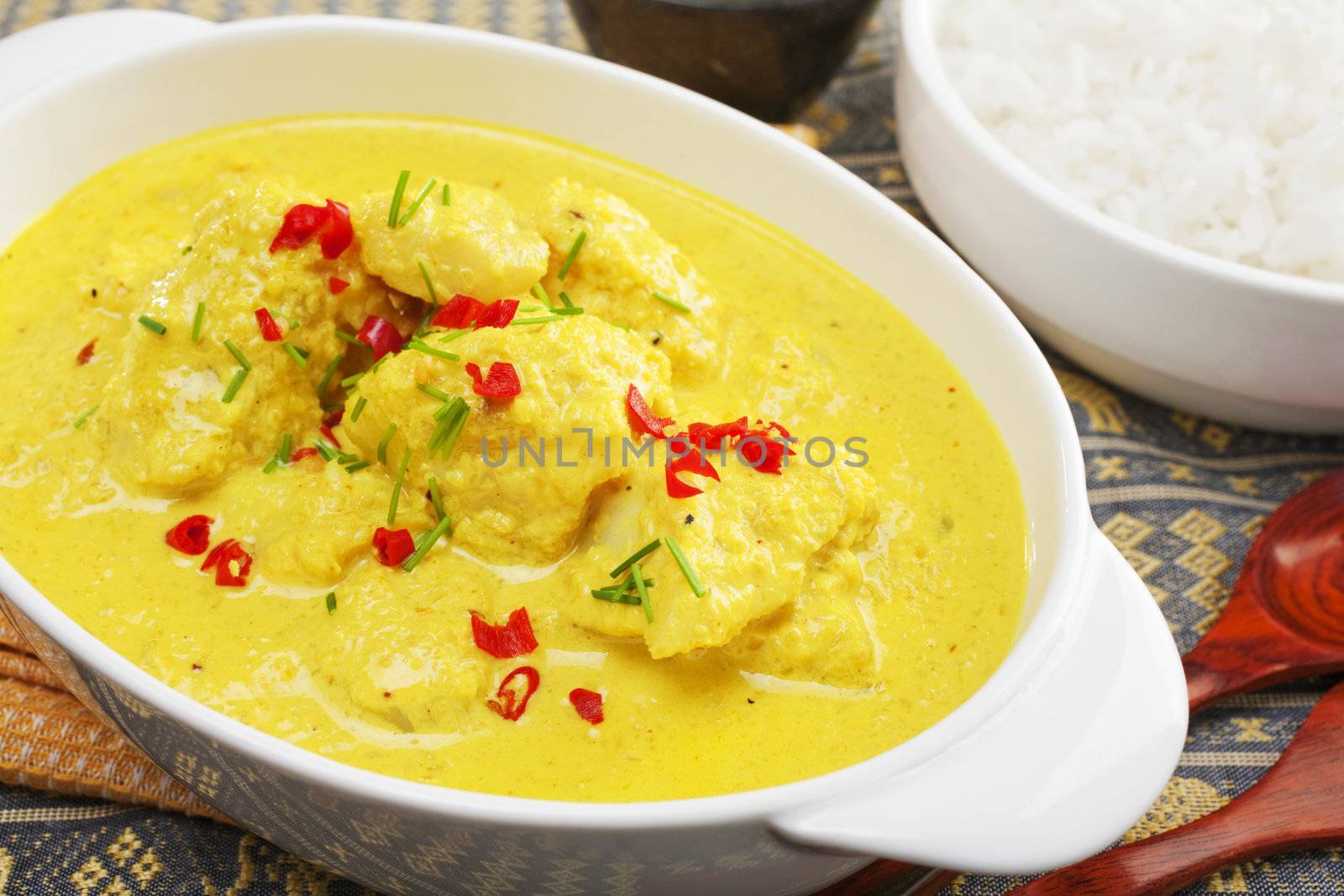 Fish cooked in spicy coconut sauce, garnished with chilli and chives,  and served with basmati rice.