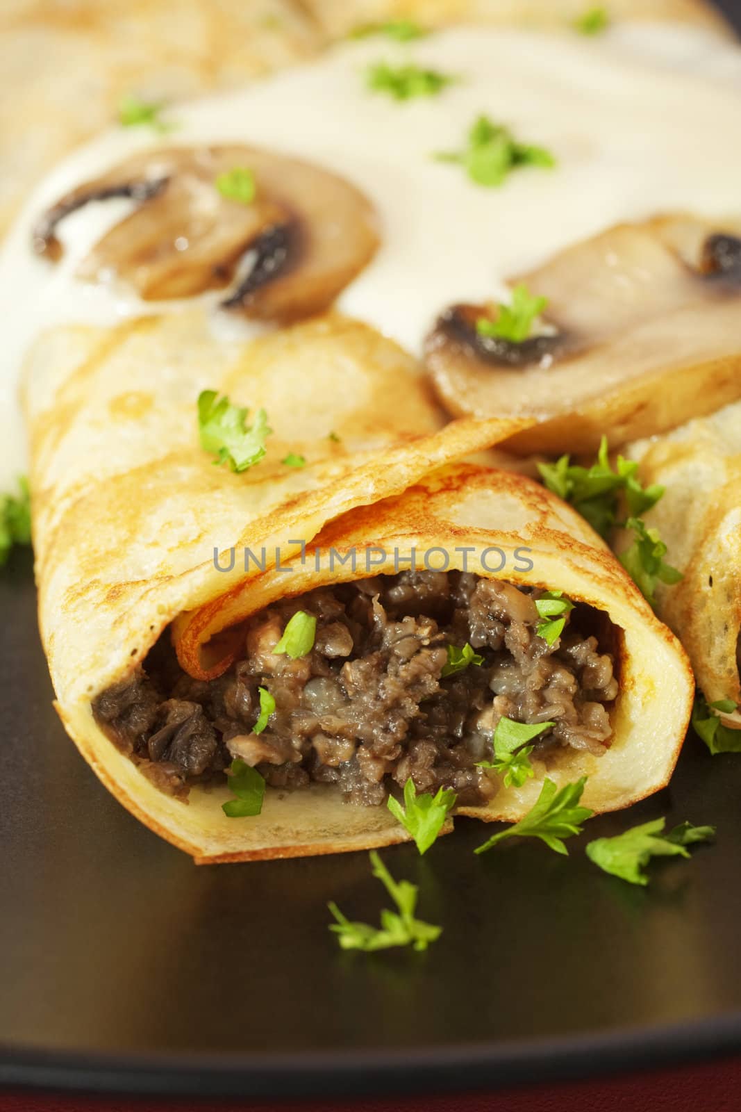 Crepes stuffed with mushroom duxelles and topped with bechamel sauce.