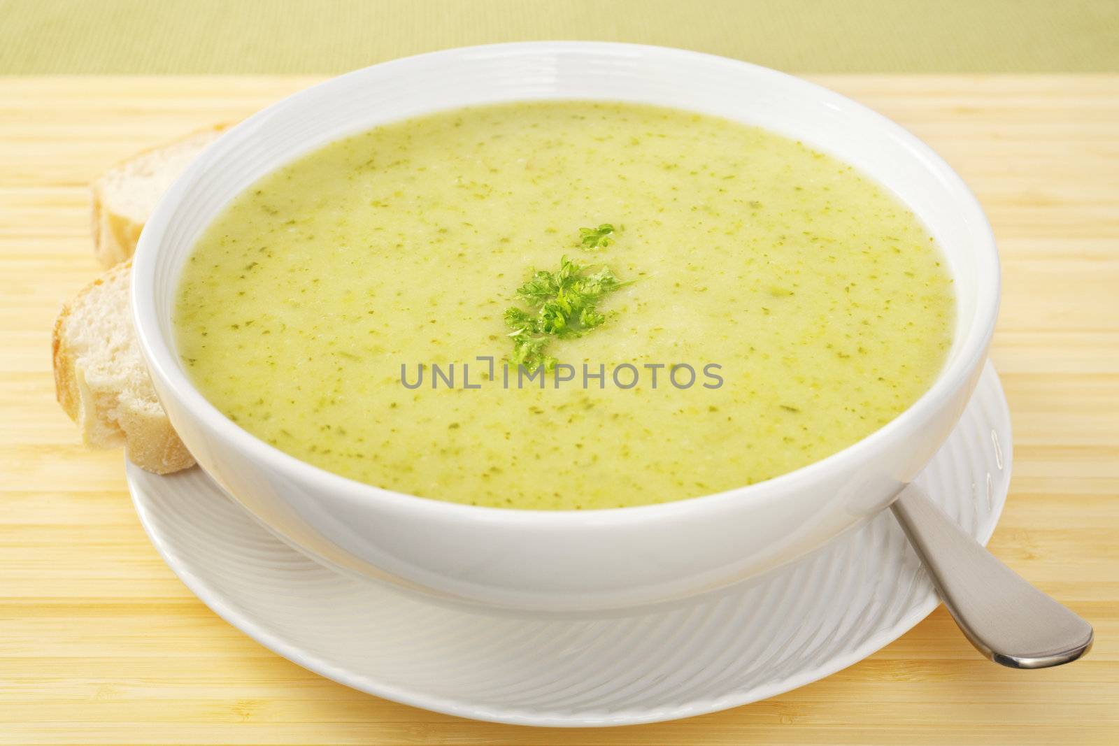 A pretty green soup made from courgettes and potato, garnished with parsley.