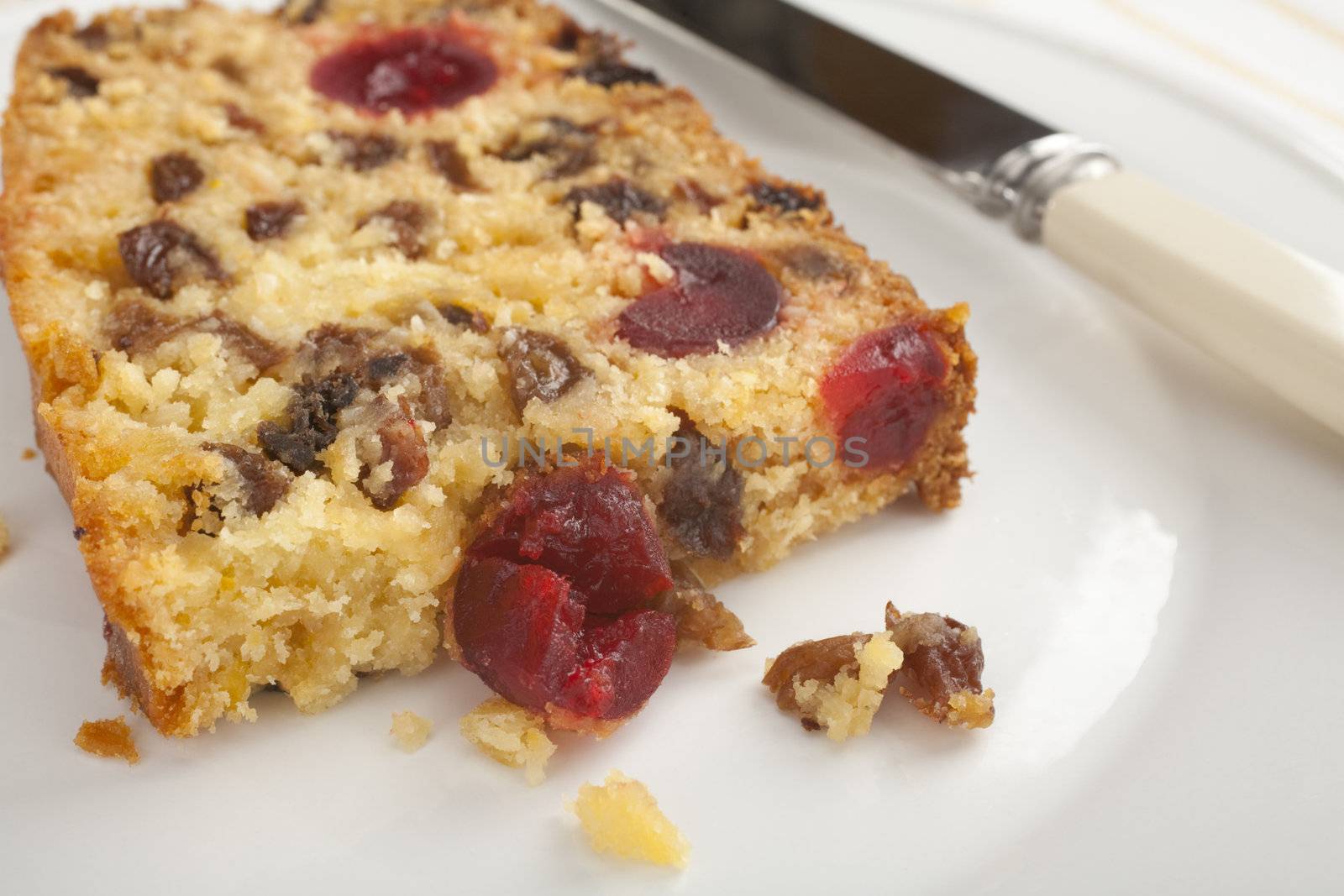 A slice of deliciously moist coconut fruit cake, stuffed with goodies like coconut, cherries, lemon and sultanas.