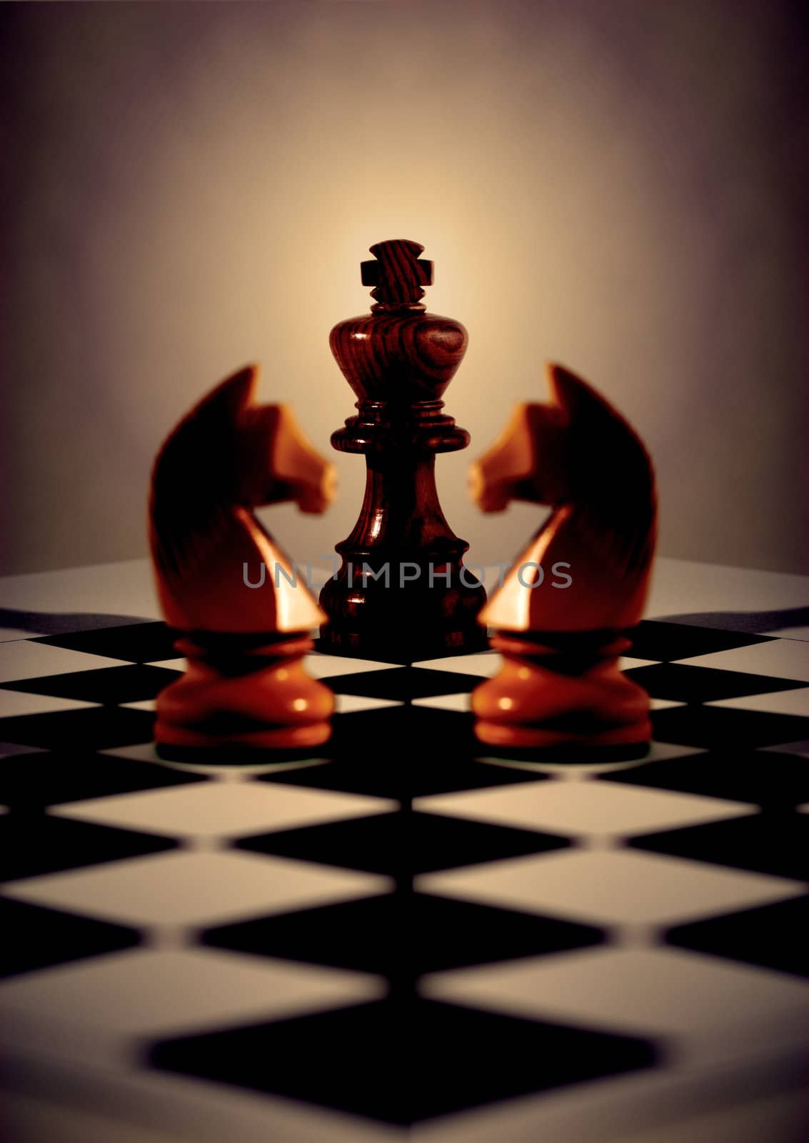 Black king with light behind, two white knights mirrored for symmetry, on diagonal chess board. Concepts business or religious or board meeting. Focus on King.