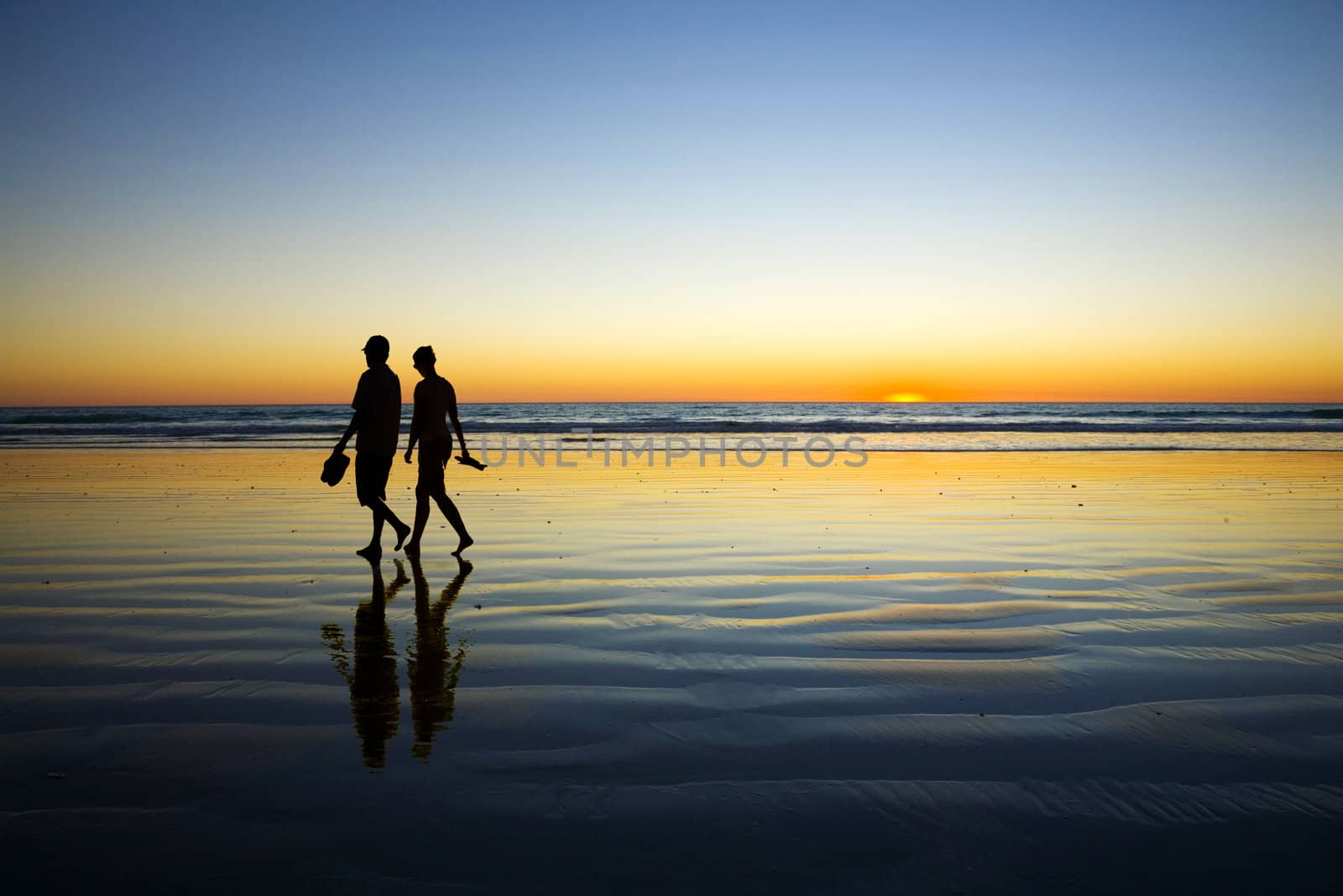 Young Couple Walking on Romantic Beach at Sunset by Travelling-light