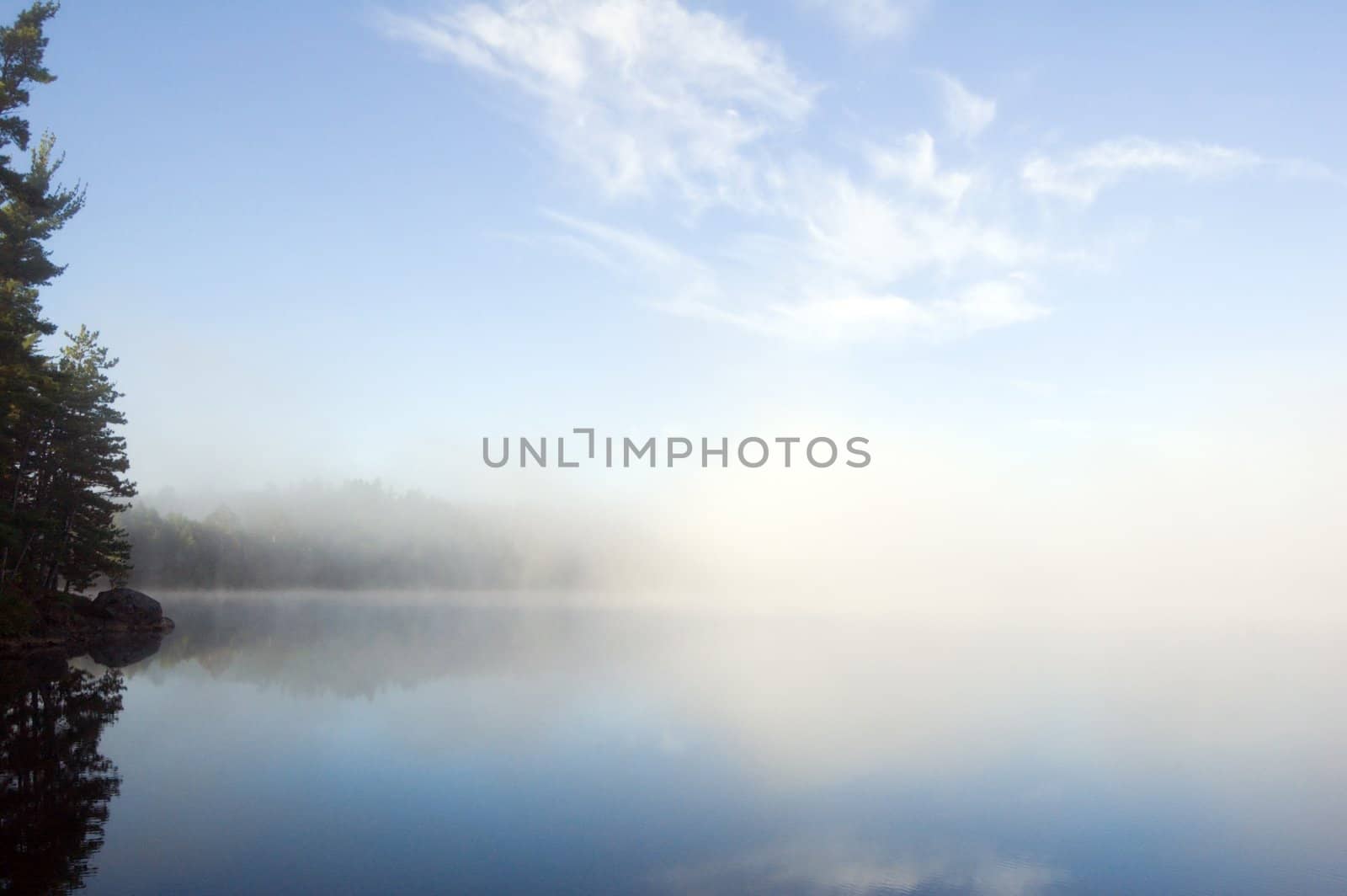 Fog above forest lake in Killarney Park in the morning