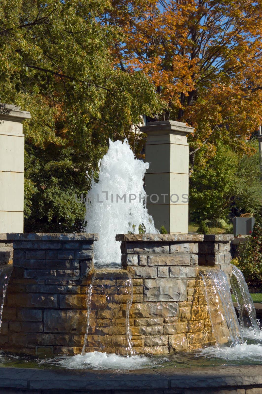 Fountain waterfall in sunlit on stone background