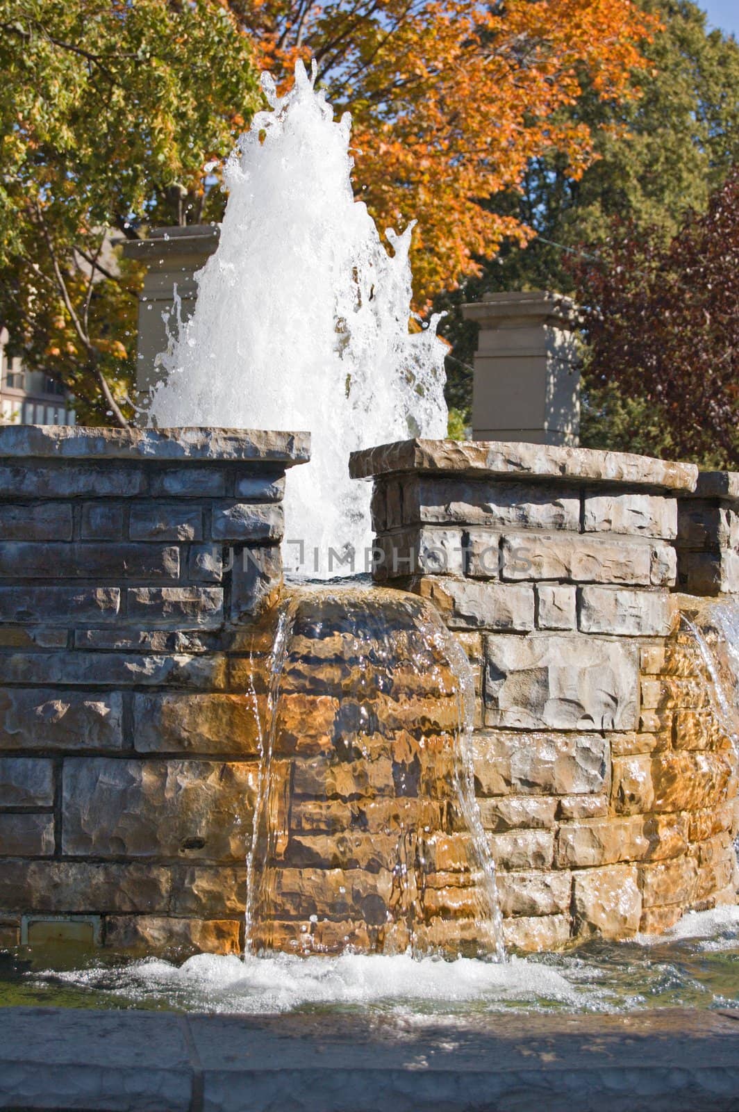 Fountain waterfall in sunlit on stone background