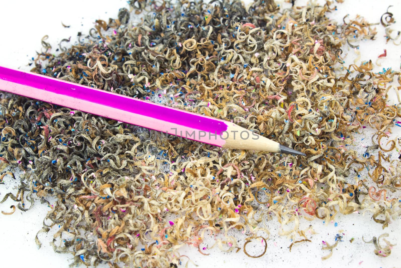 Pencil with sharpening shavings on white background