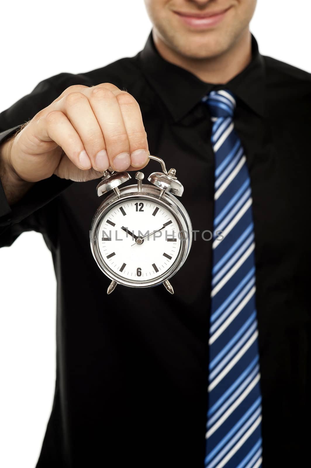 Business executive holding alarm clock over white background. Cropped image