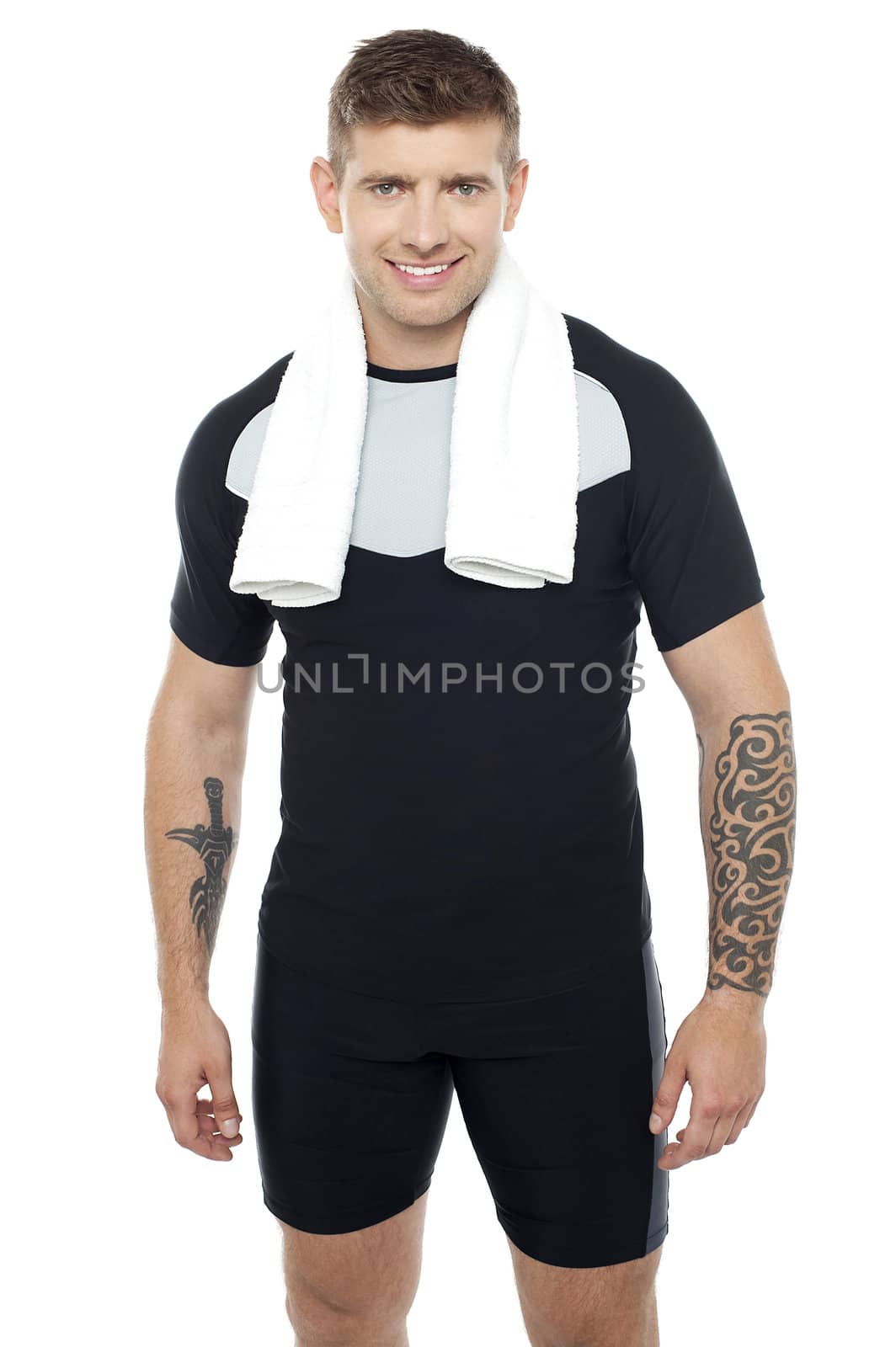 Young fit guy posing after gym workout. Tattoos on hands