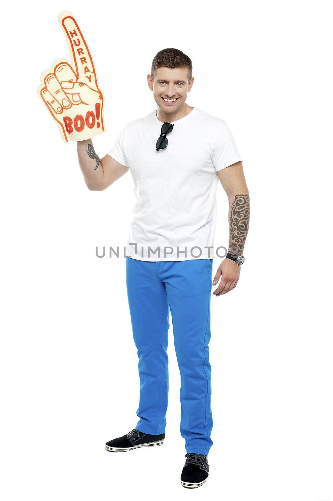 Handsome young smiling sports fan wearing huge foam hand cheering his home team