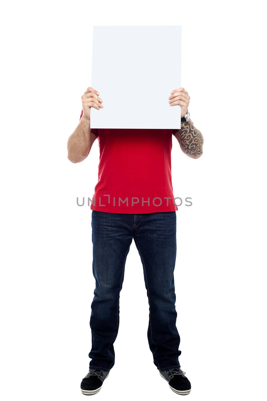 Full length portrait of casual man hiding his face behind blank white ad board