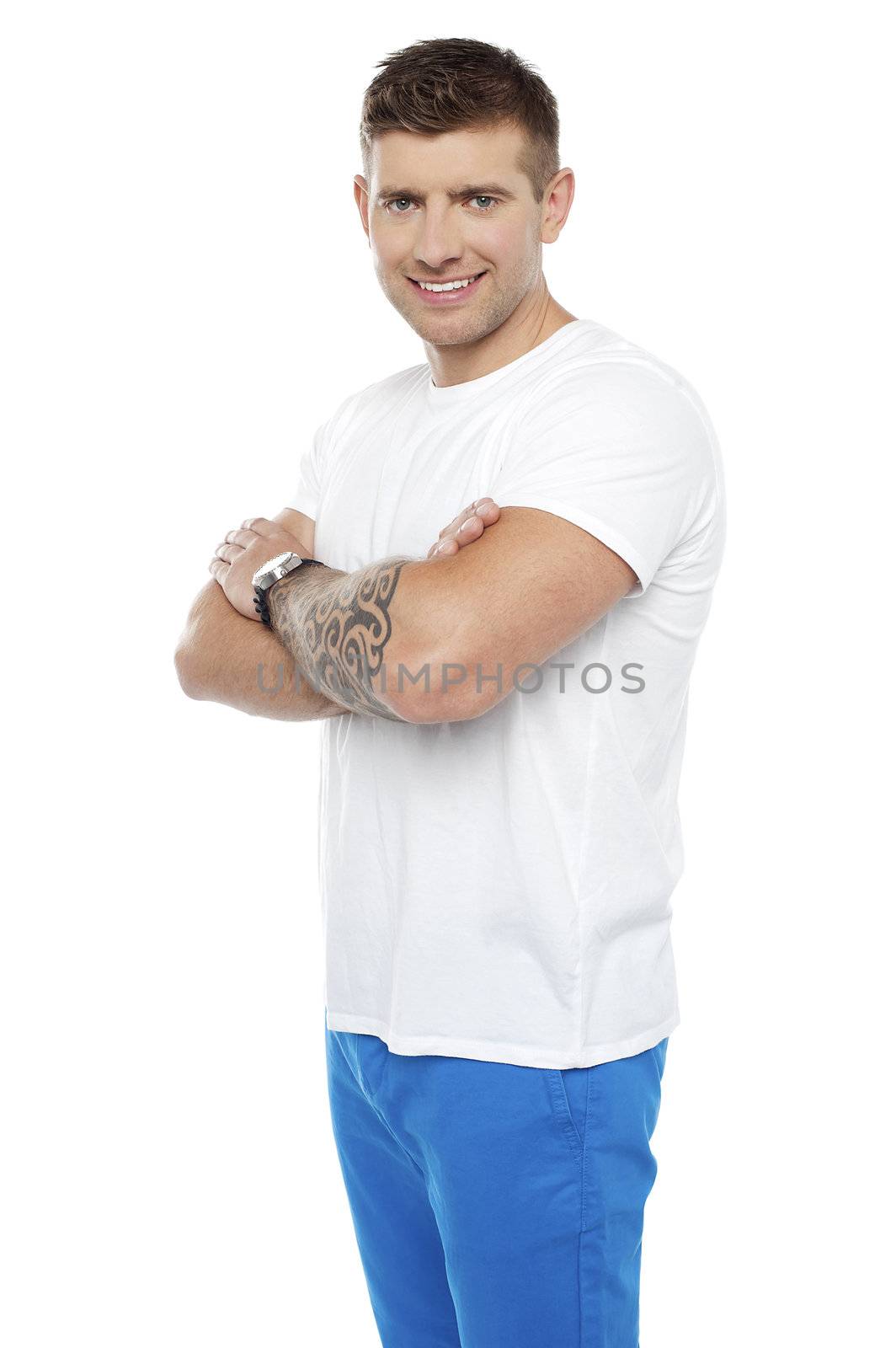 Smart young man posing with crossed arms. Tattoo on his hands