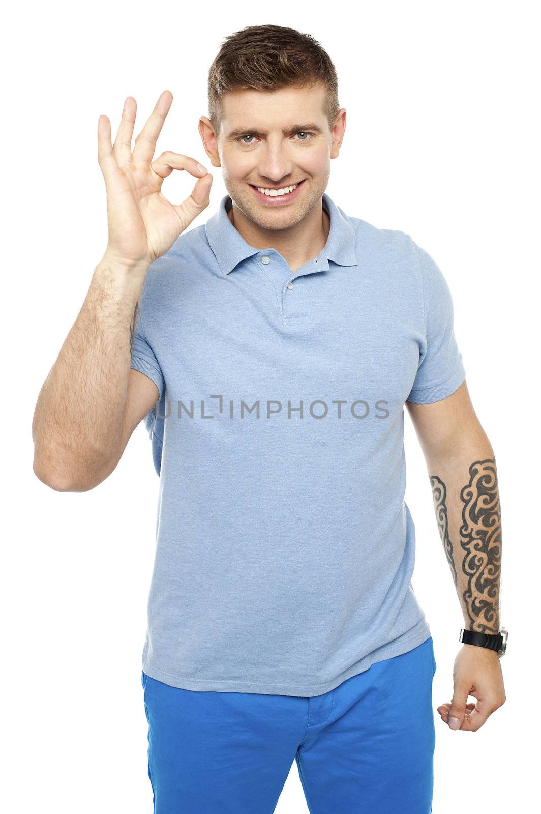 Smart smiling man gesturing okay sign. Tattoo engraved on hand