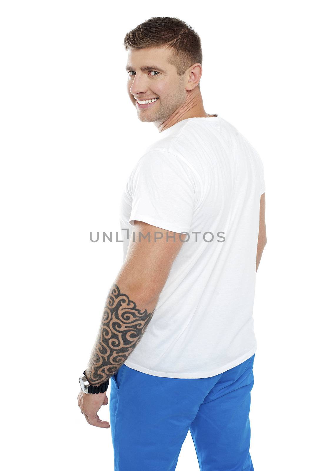 Young smiling man with tattoo on hand turning back towards camera