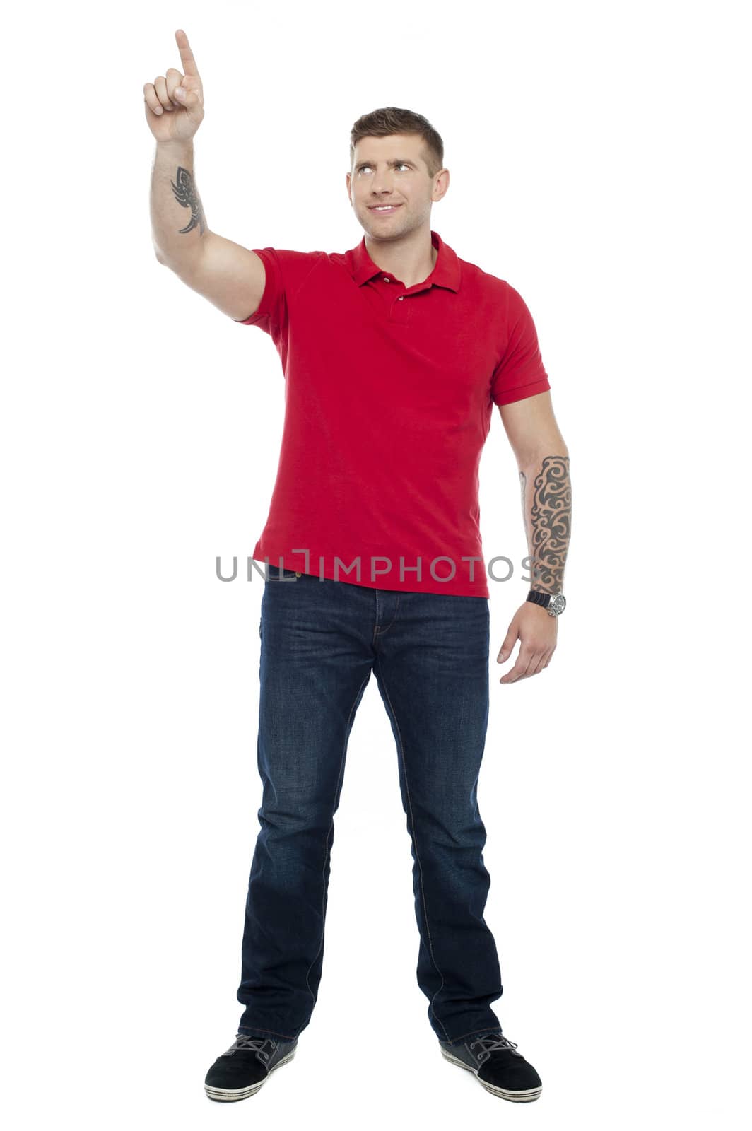 Full length shot of handsome guy pointing upwards