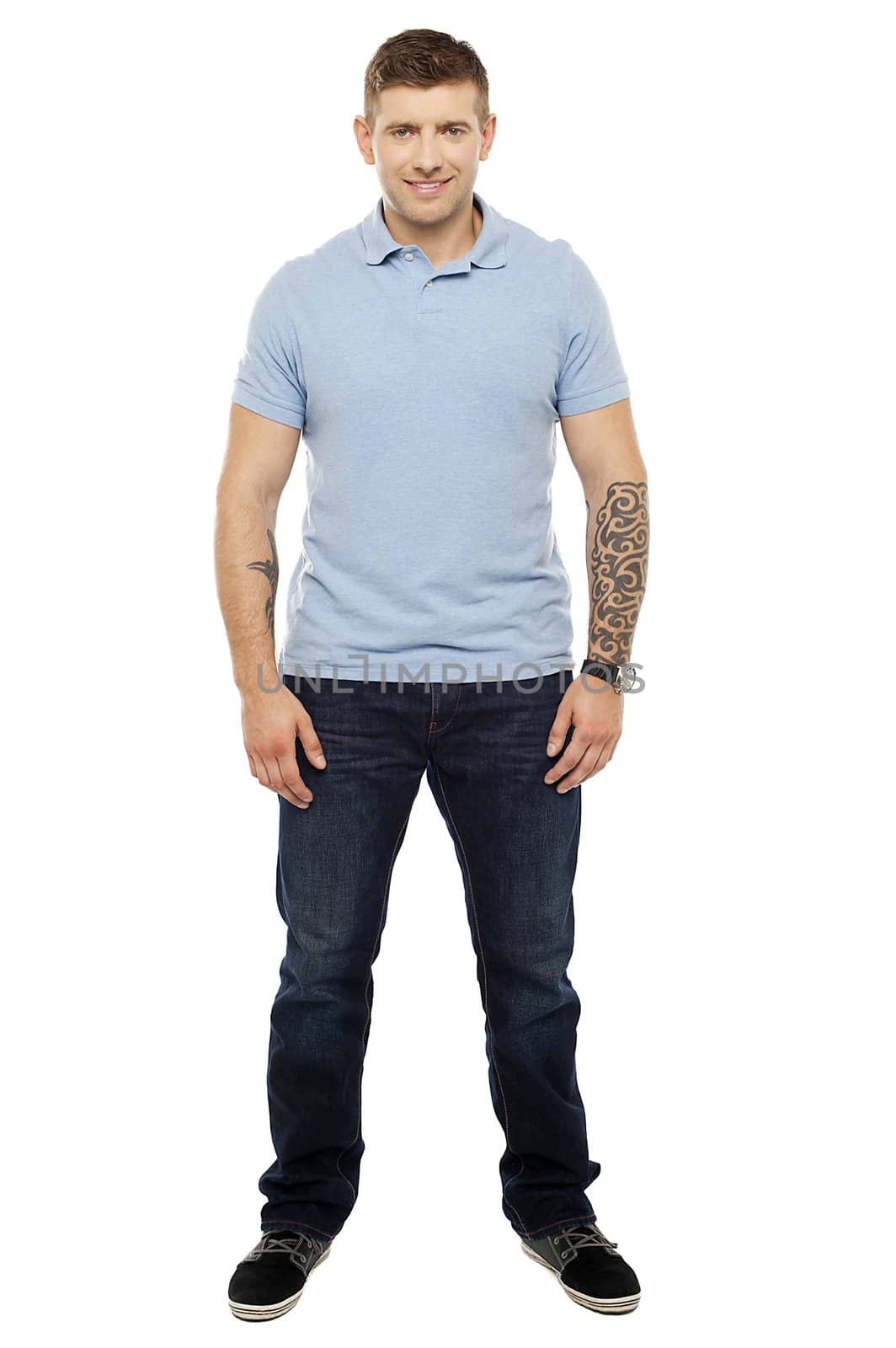 Smiling handsome man with tattoos in both the hands. Full length shot