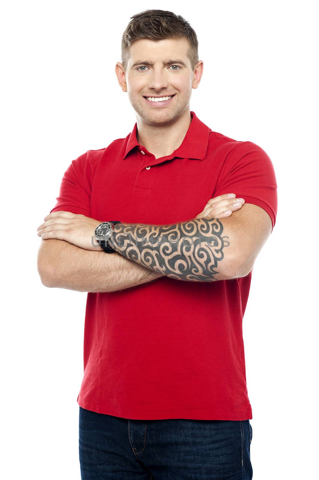 Stylish man with tattoo on hand posing with folded arms isolated over white