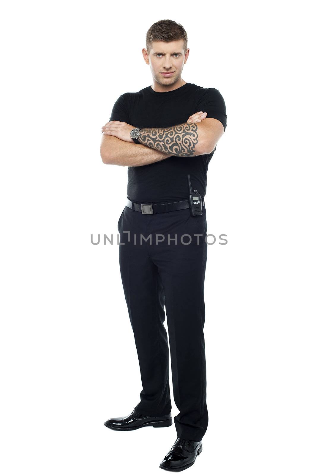 Bodyguard with tattoo. Posing with folded arms, looking at you