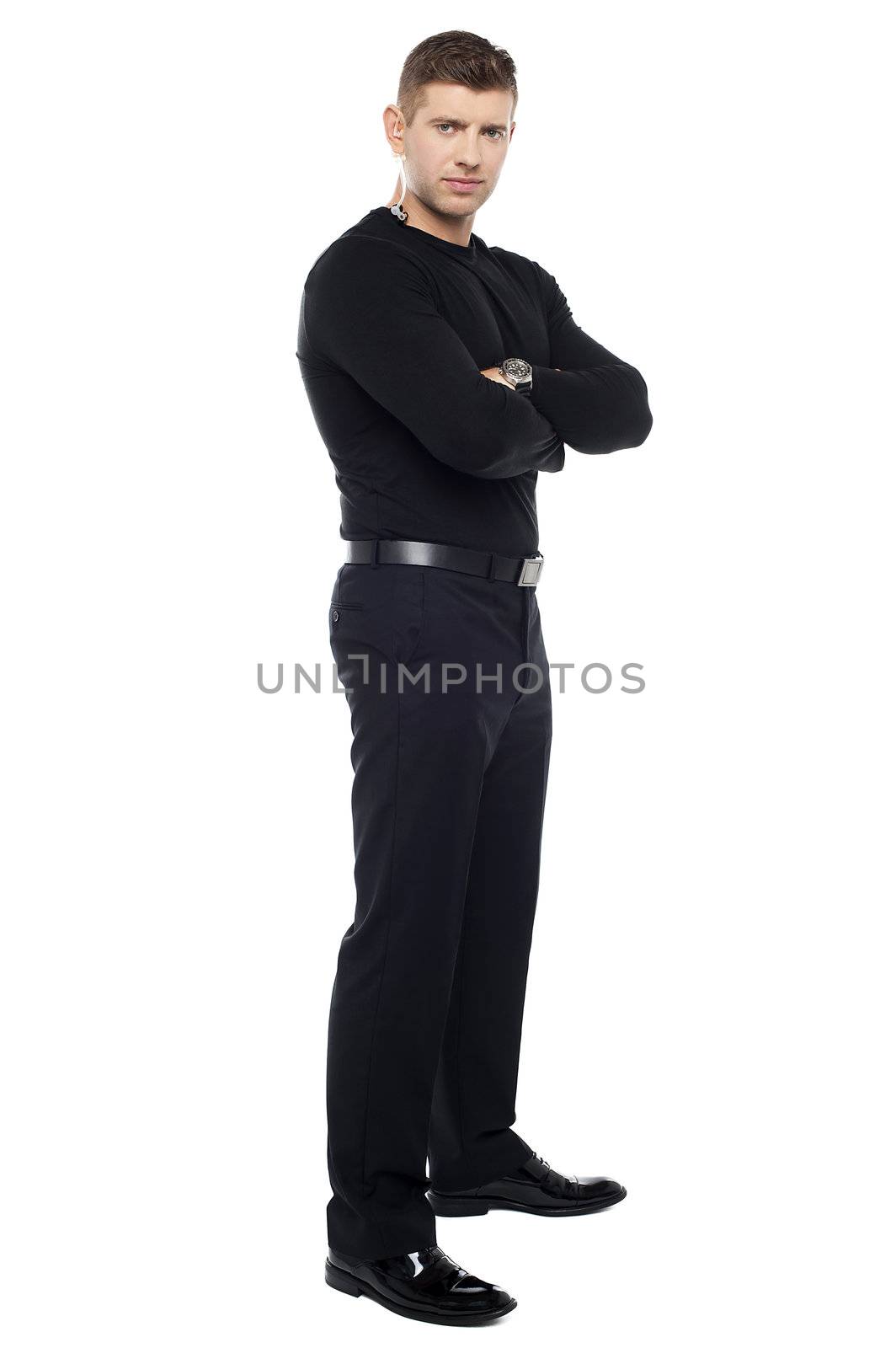 Handsome young bodyguard, full length portrait. Arms folded