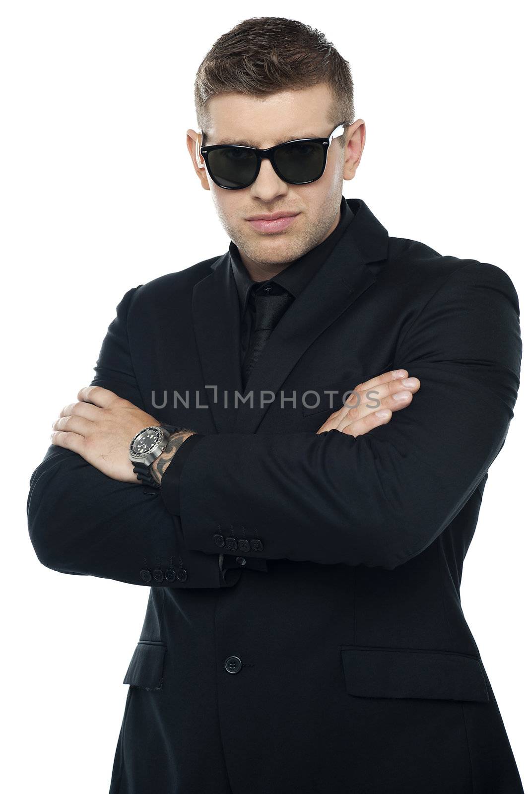 Young stylish bouncer in a black suit, arms folded. Half length portrait