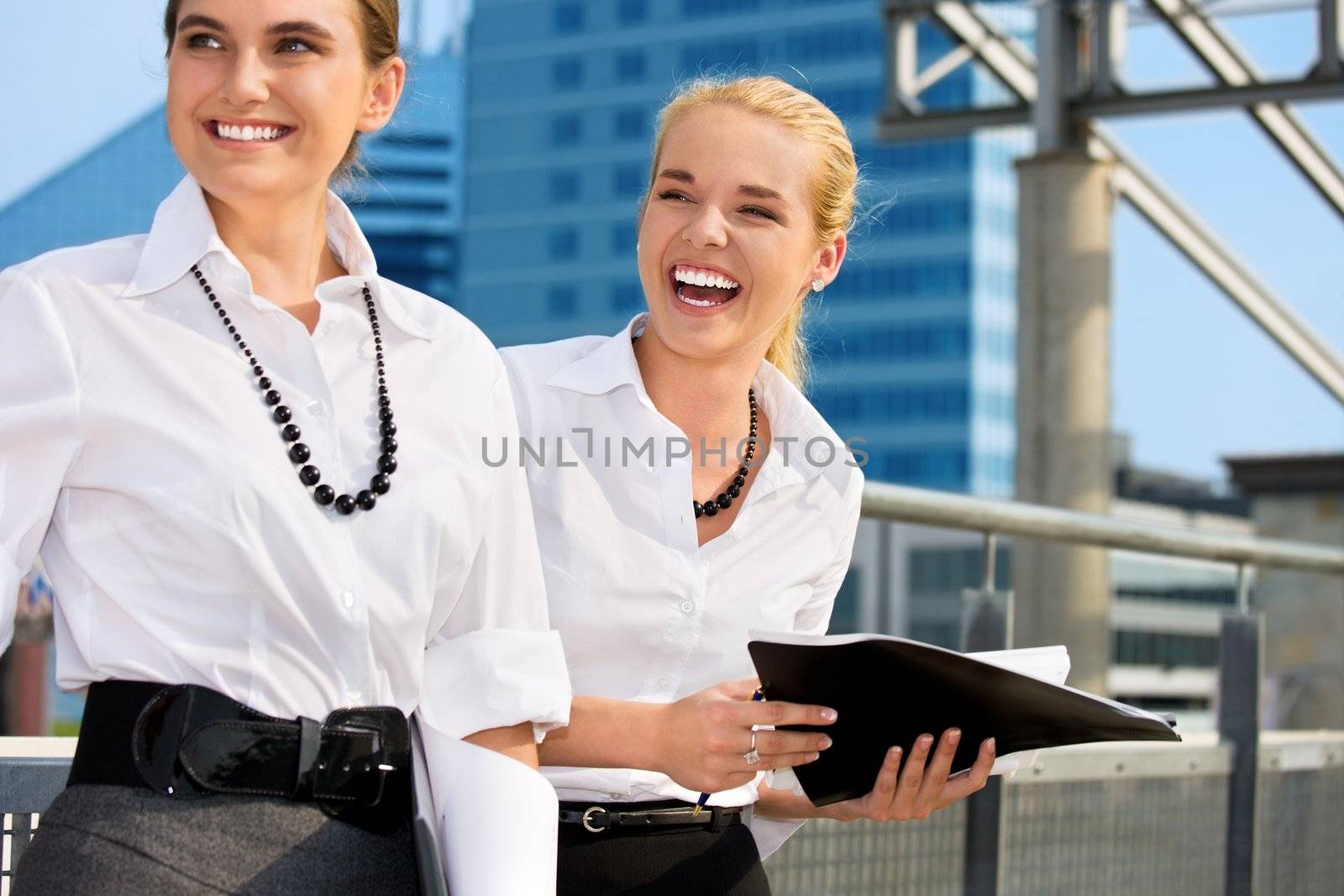 two happy businesswomen with folders (focus on blonde)