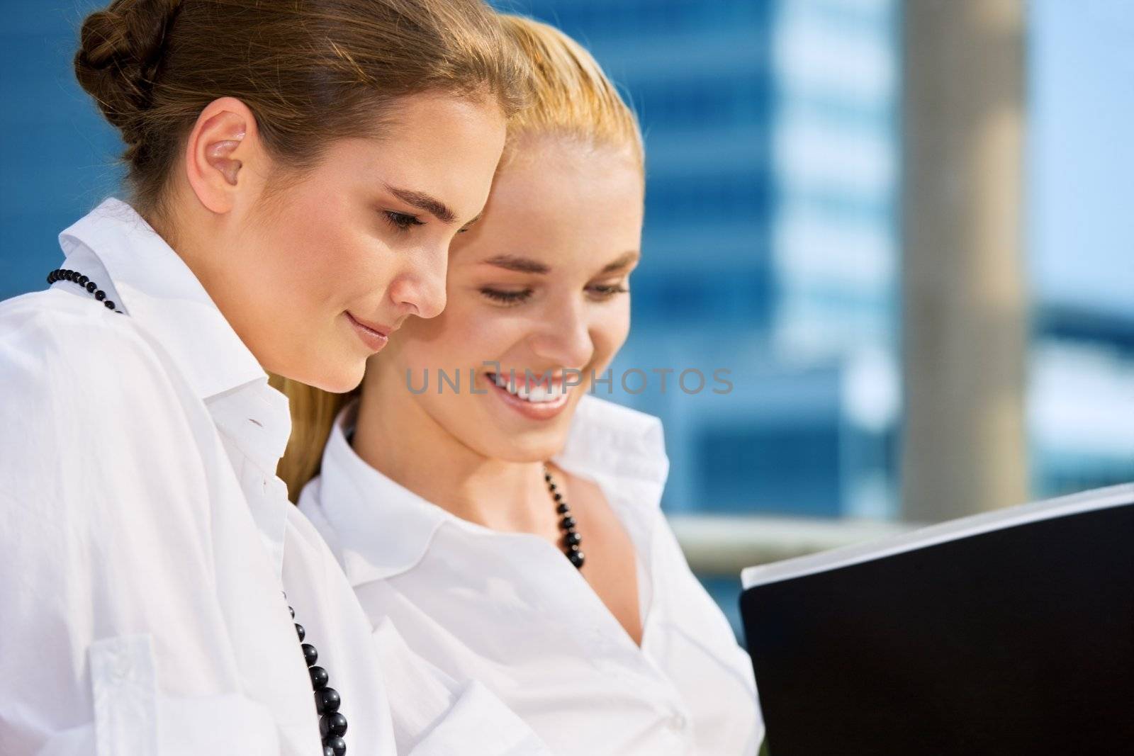 two happy businesswomen with documents (focus on brunette)