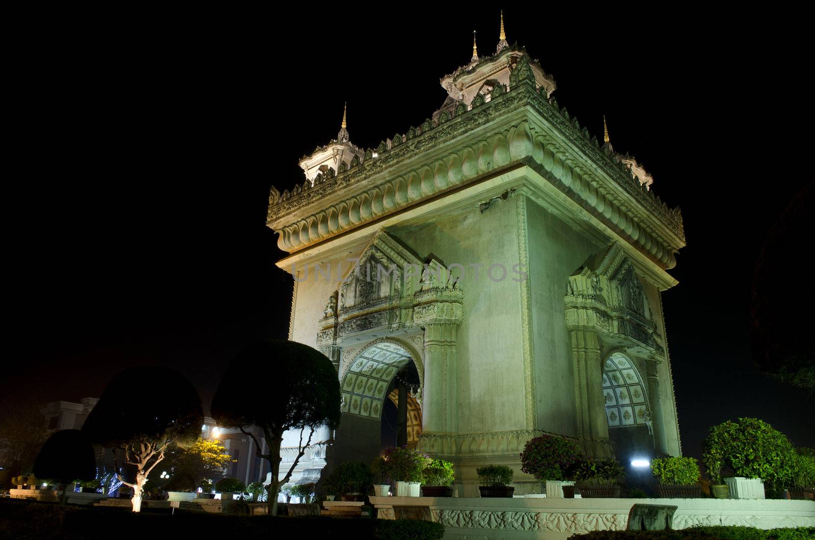 patuxai arch at night in vientiane, laos by jackmalipan