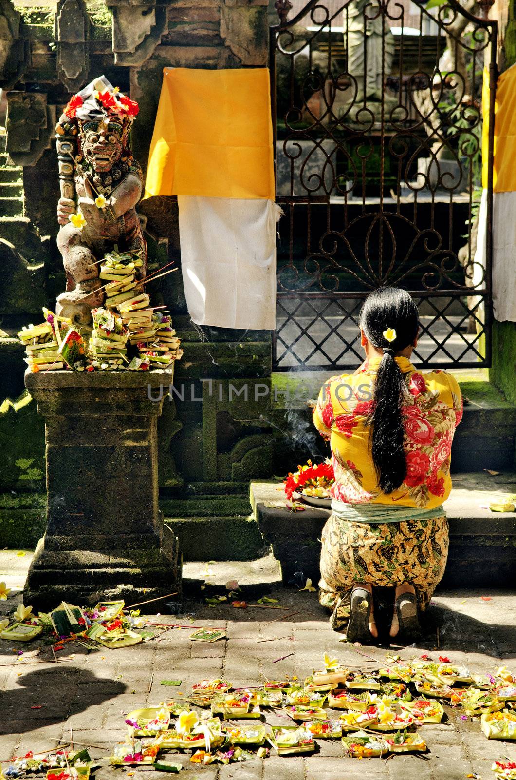 woman praying in temple bali indonesia by jackmalipan