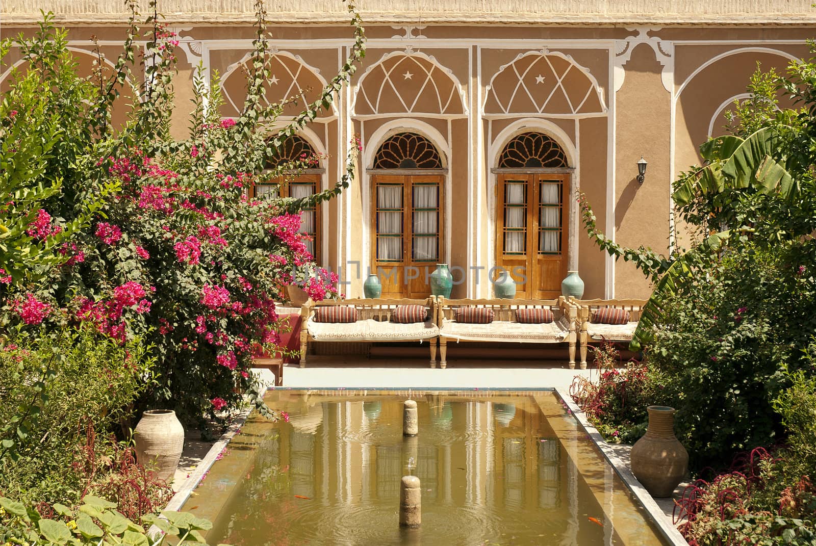 hotel interior garden with pond in yazd iran by jackmalipan