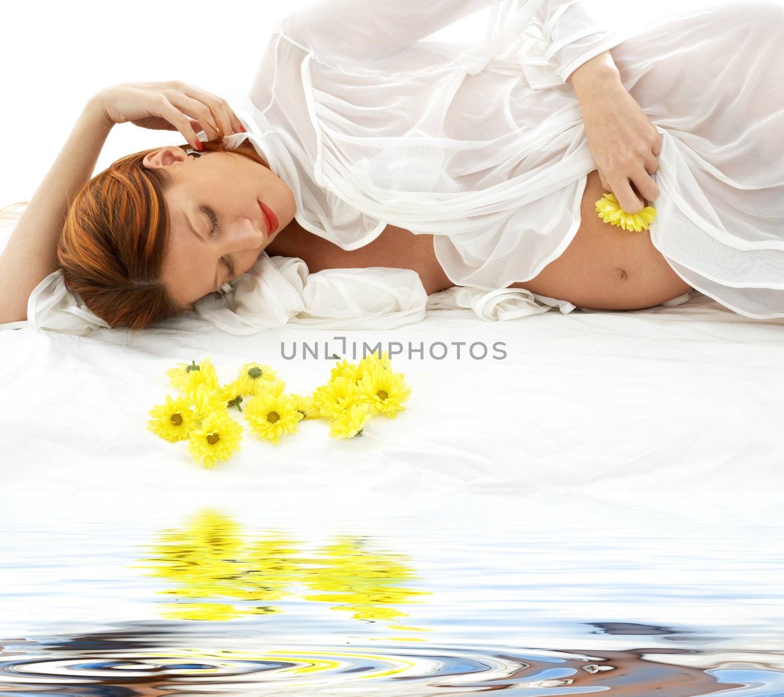 beautiful pregnant redhead woman with yellow flowers