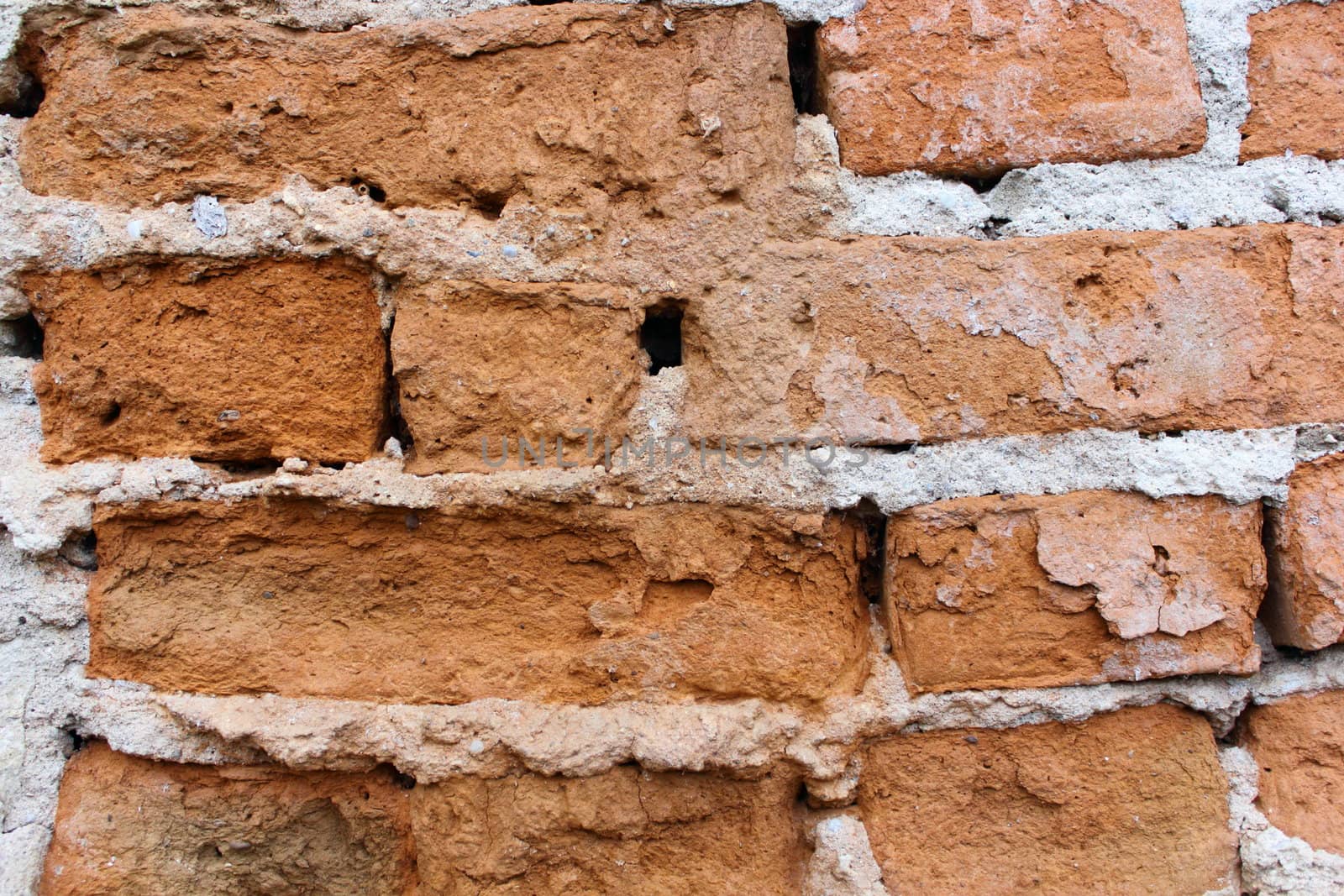 textured old bricks at the exterior wall of an abandoned house