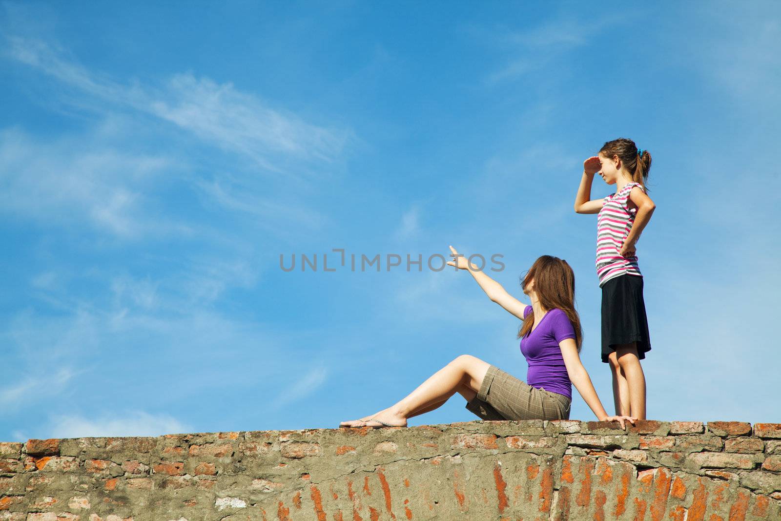 Two teen girls outdoors looking far away