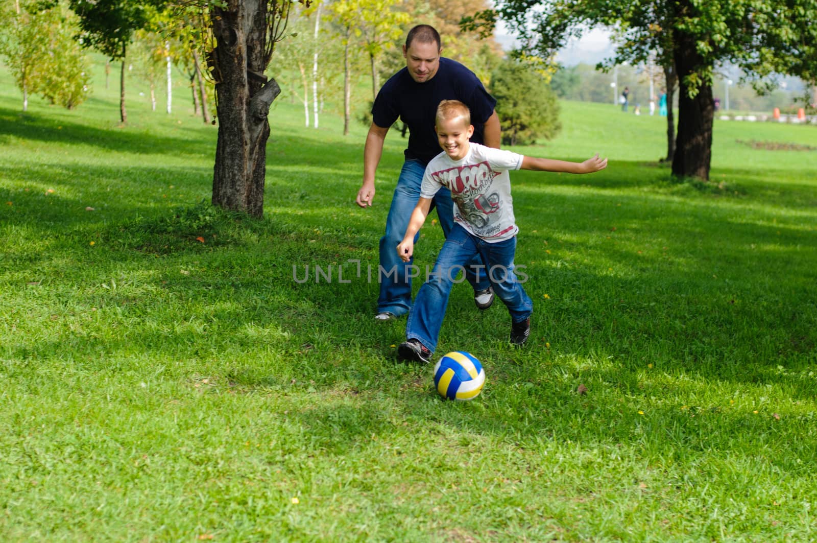 Young boy playing football with his father by nvelichko