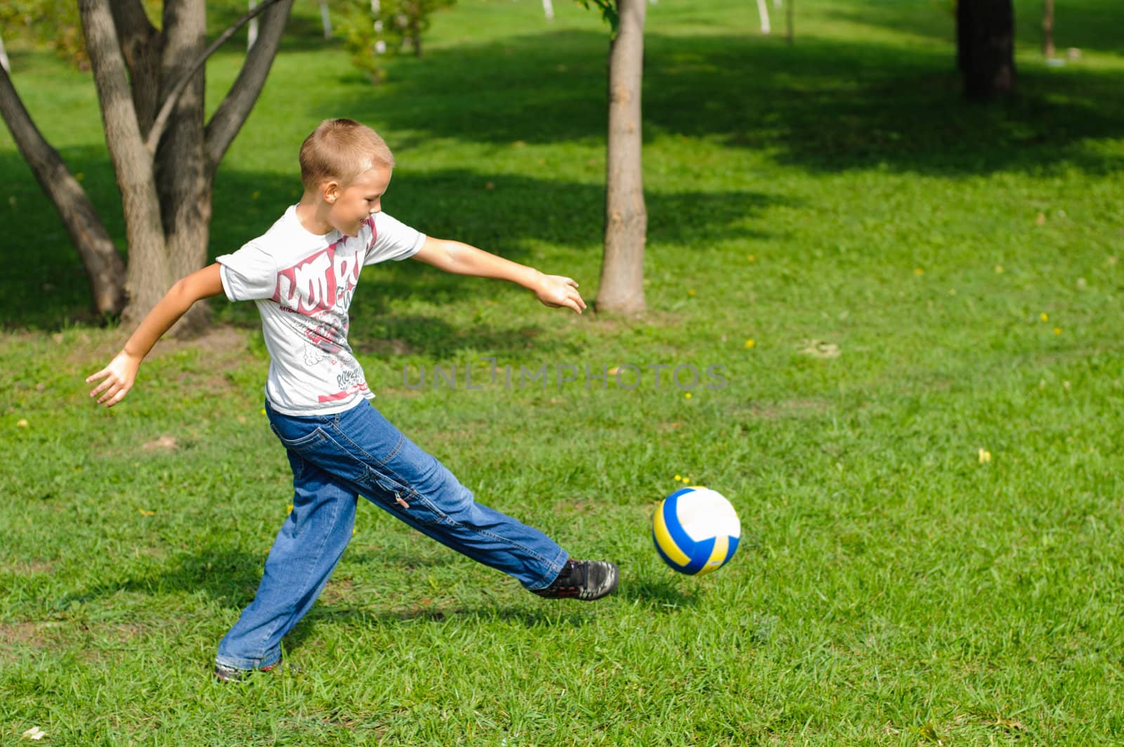 Young boy playing football outdoors by nvelichko