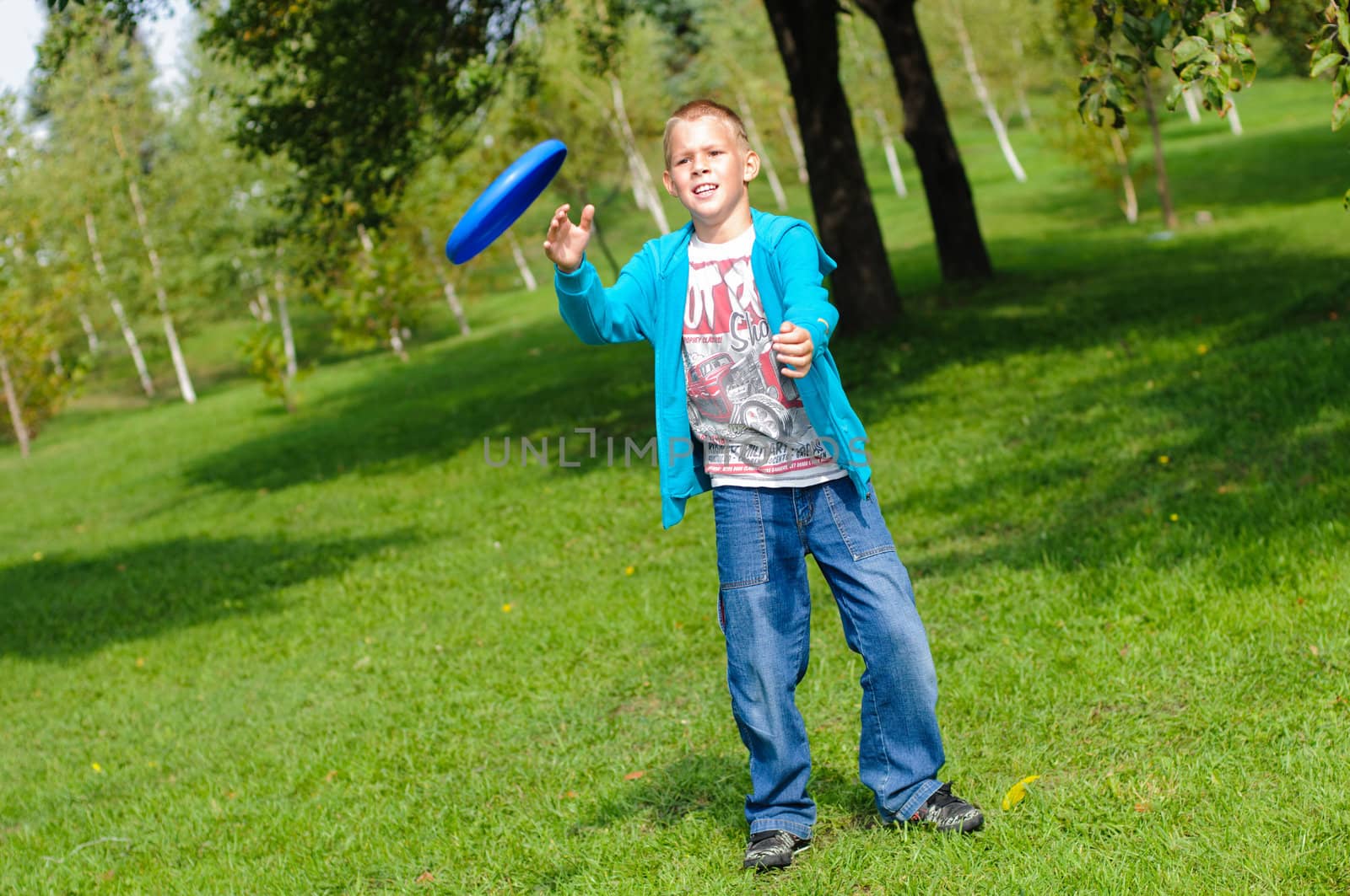 Little boy playing frisbee by nvelichko