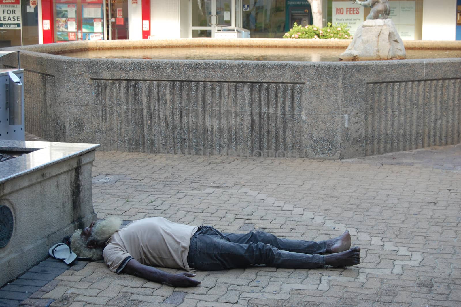 Drunk aboriginal is having a rest in the city street