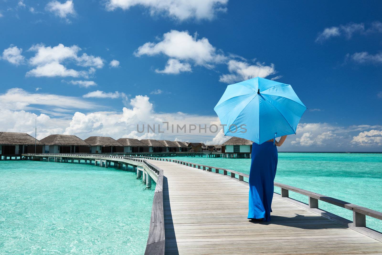 Woman on a beach jetty at Maldives by haveseen