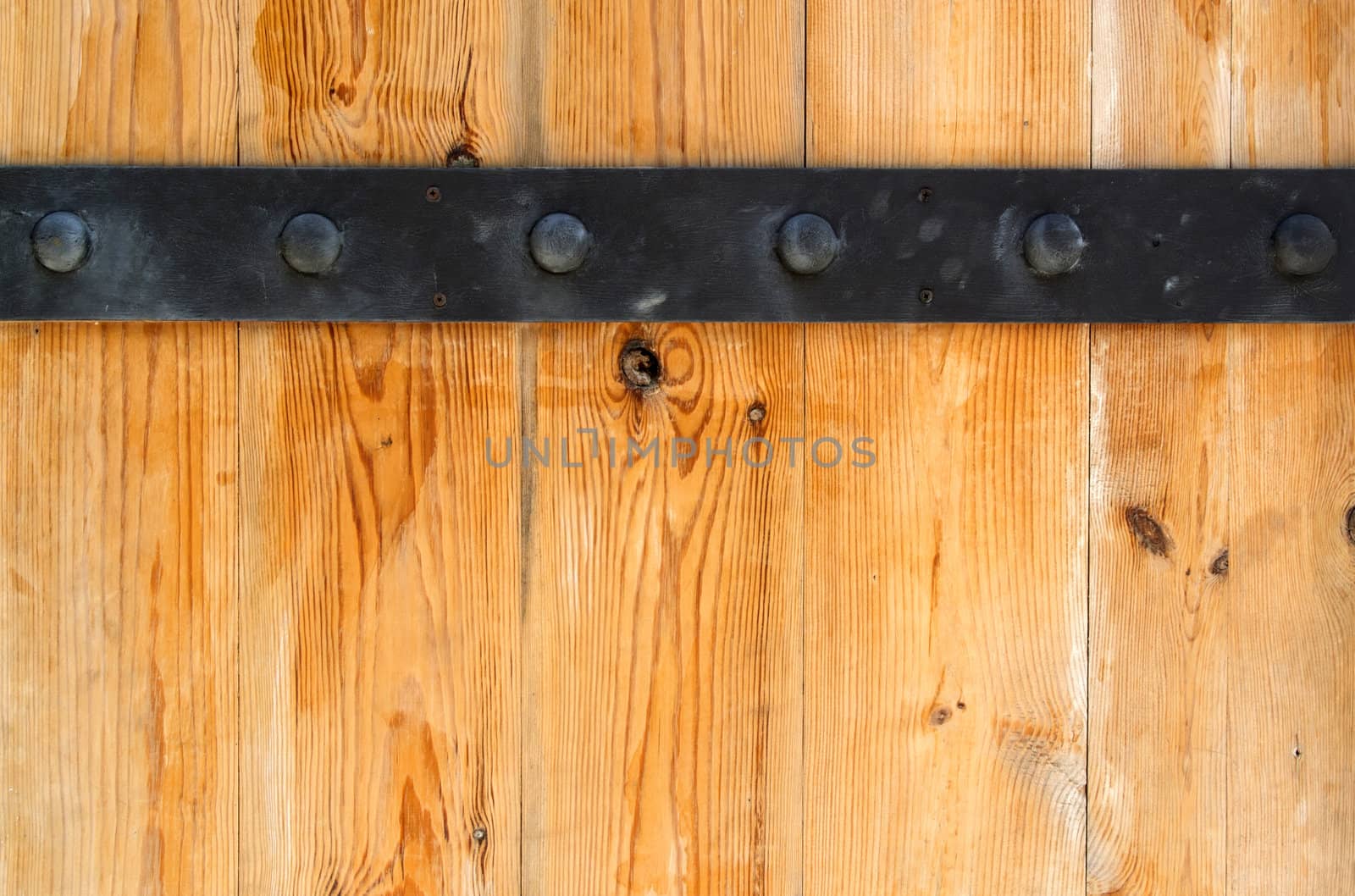 Detail of wooden door and black metal hinge