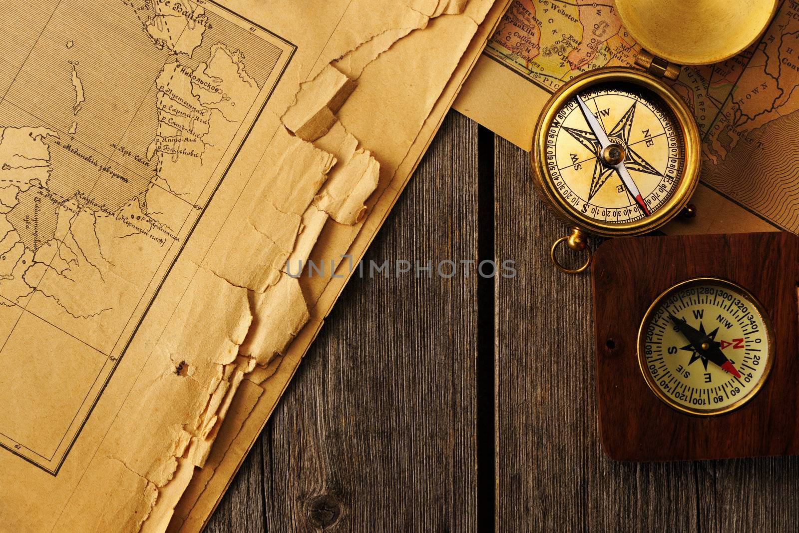 Antique brass compass over old map