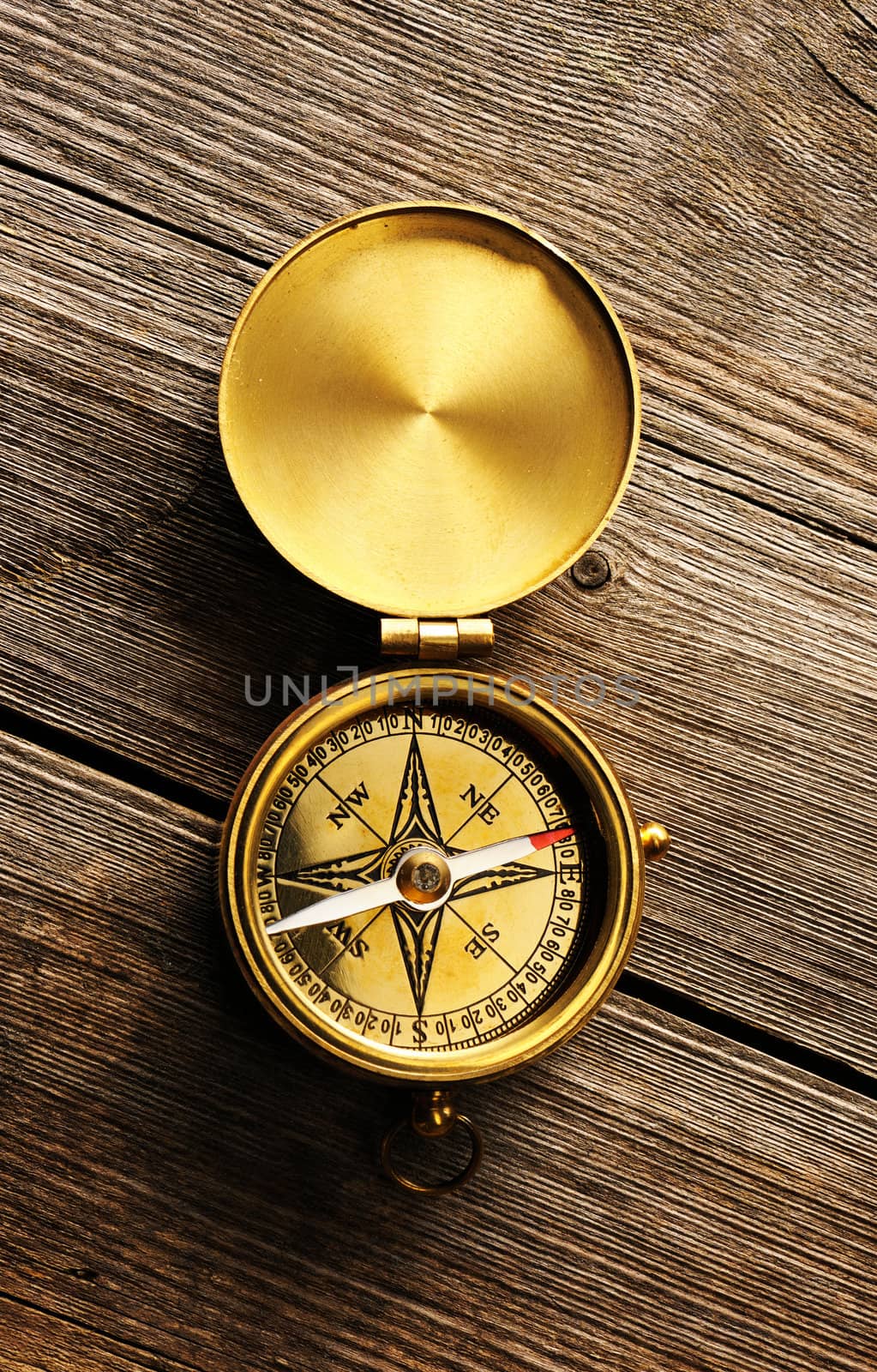 Antique compass over wooden background by haveseen