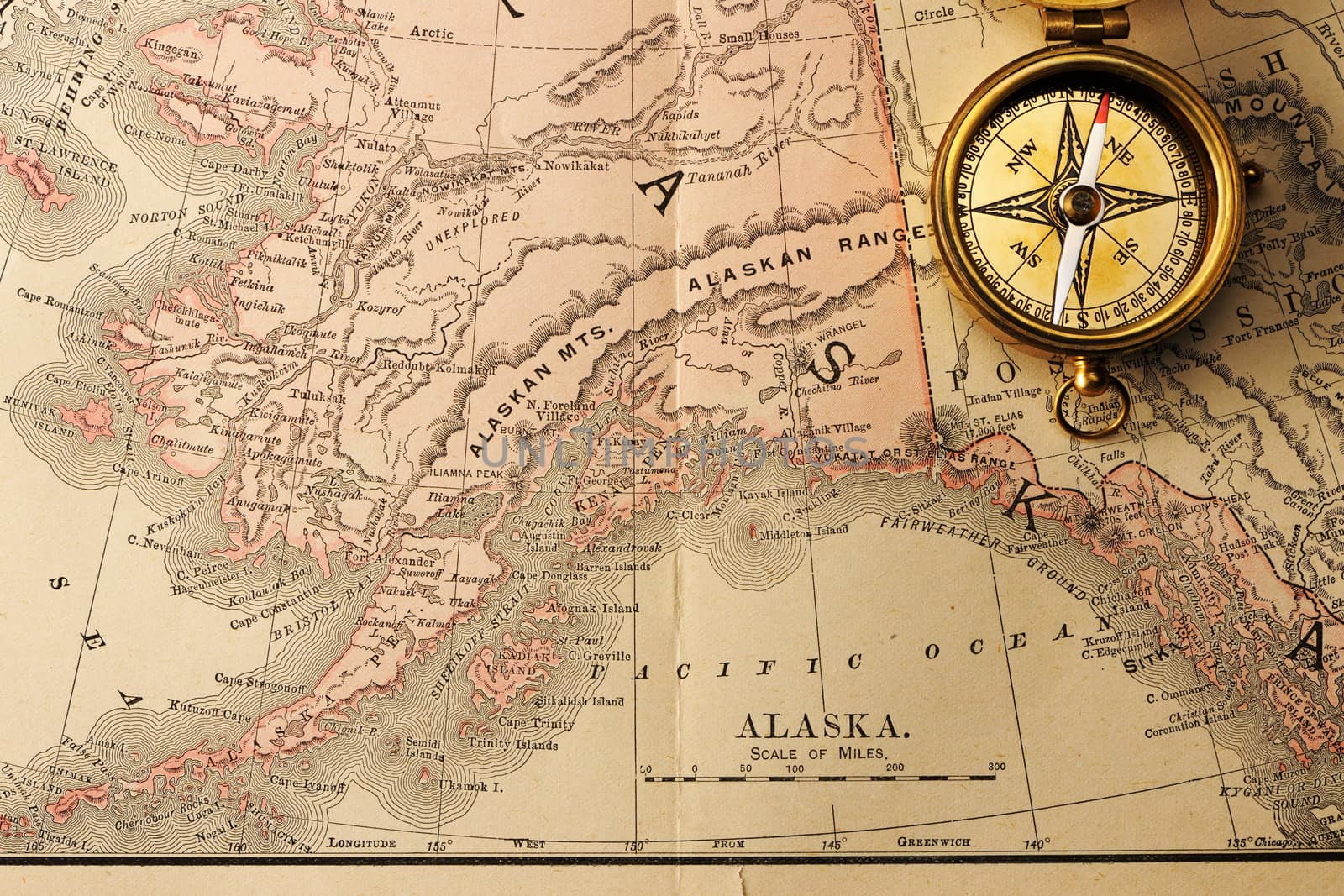 Antique brass compass over old XIX century map
