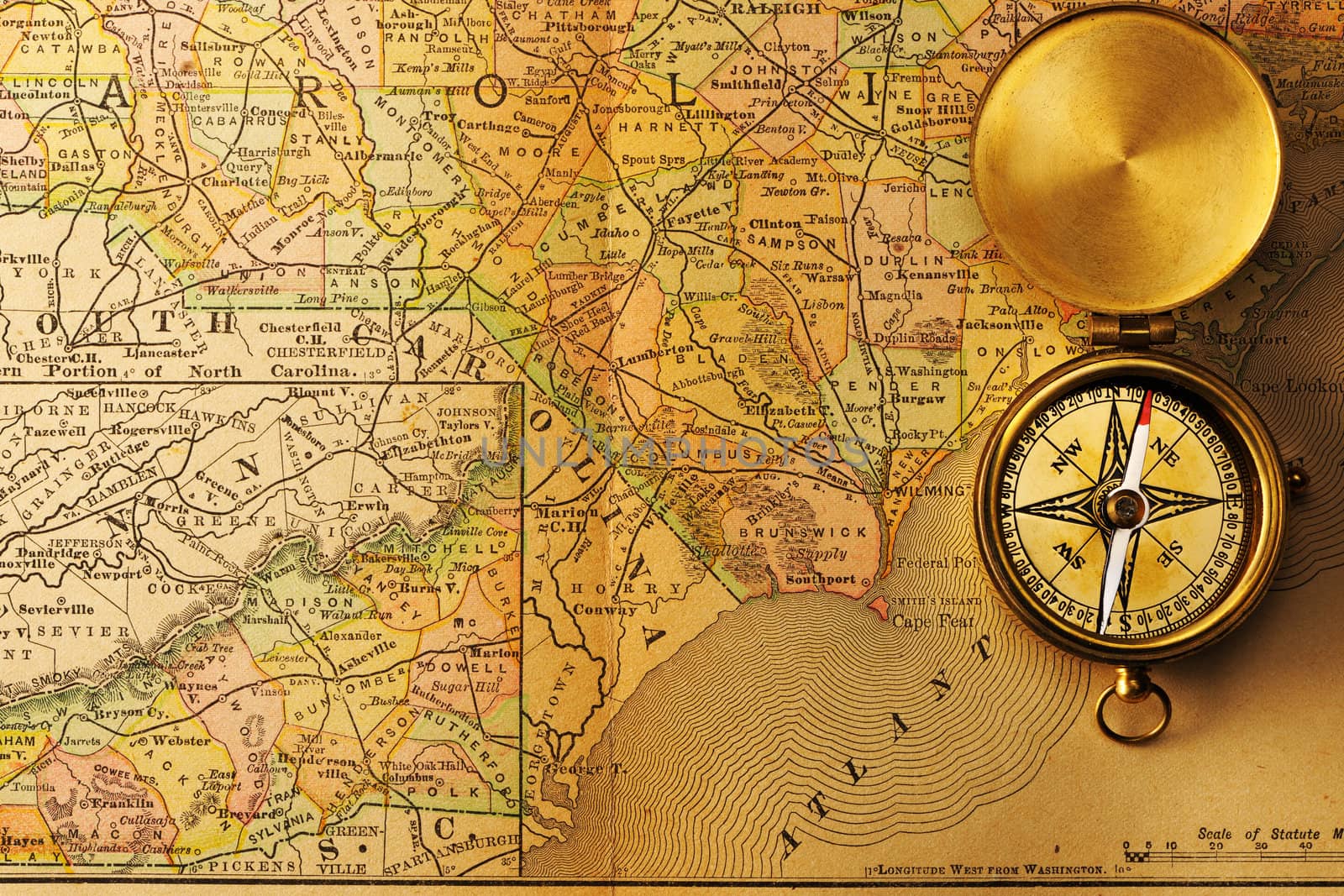 Antique brass compass over old XIX century map
