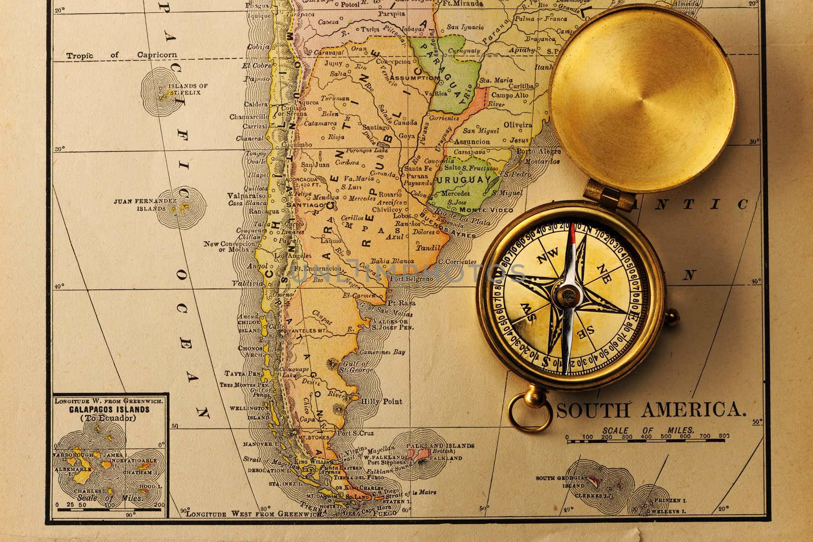 Antique brass compass over old XIX century map