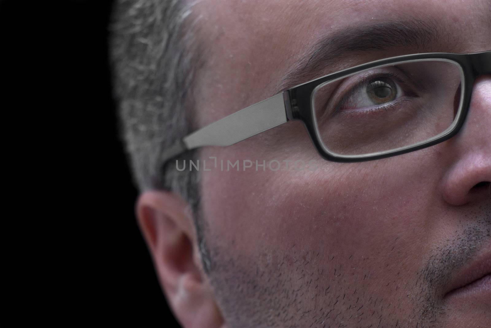 Close up portrait of man with glasses on black background