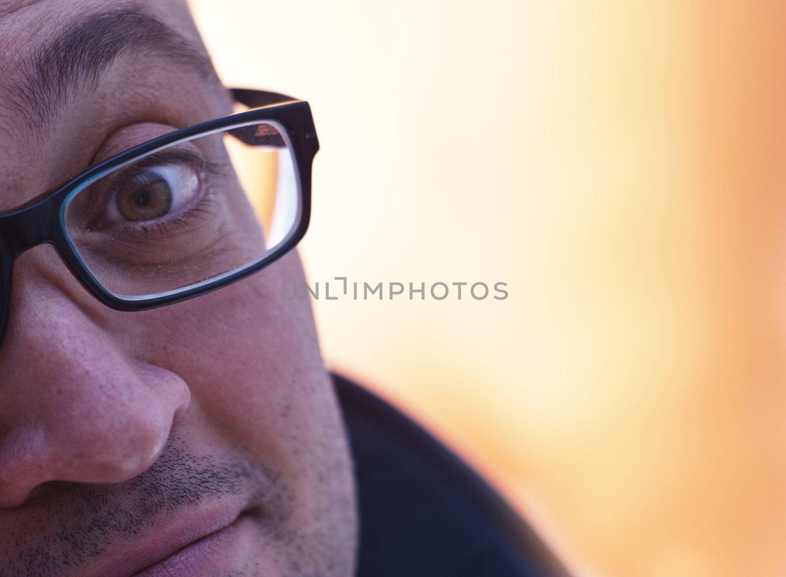 Close up portrait of man with glasses on orange background