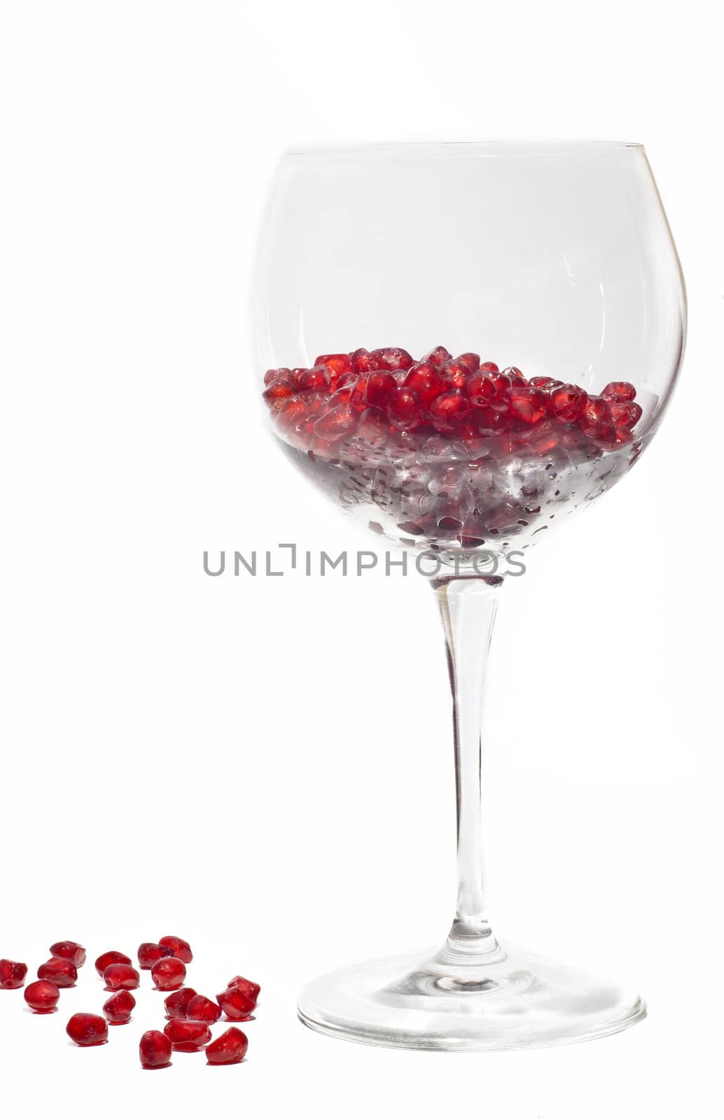 fresh grains of pomegranate in wine glass isolated on white background