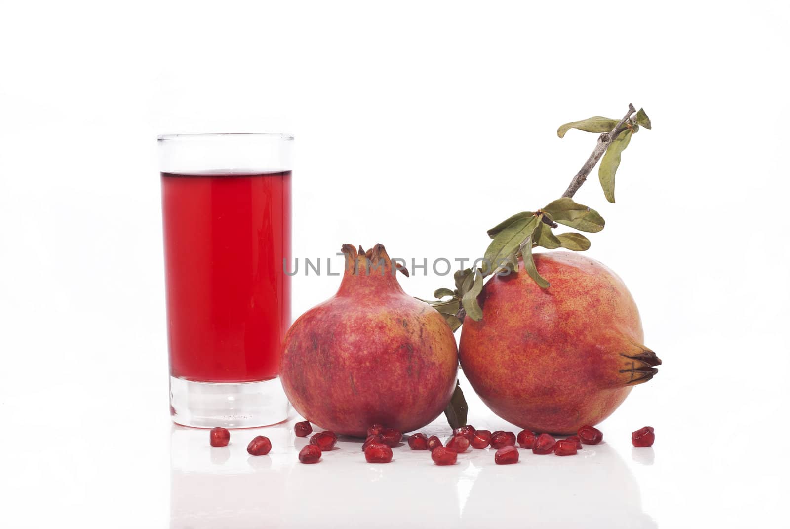 fresh ripe pomegranate and juice in the glass isolated on white background