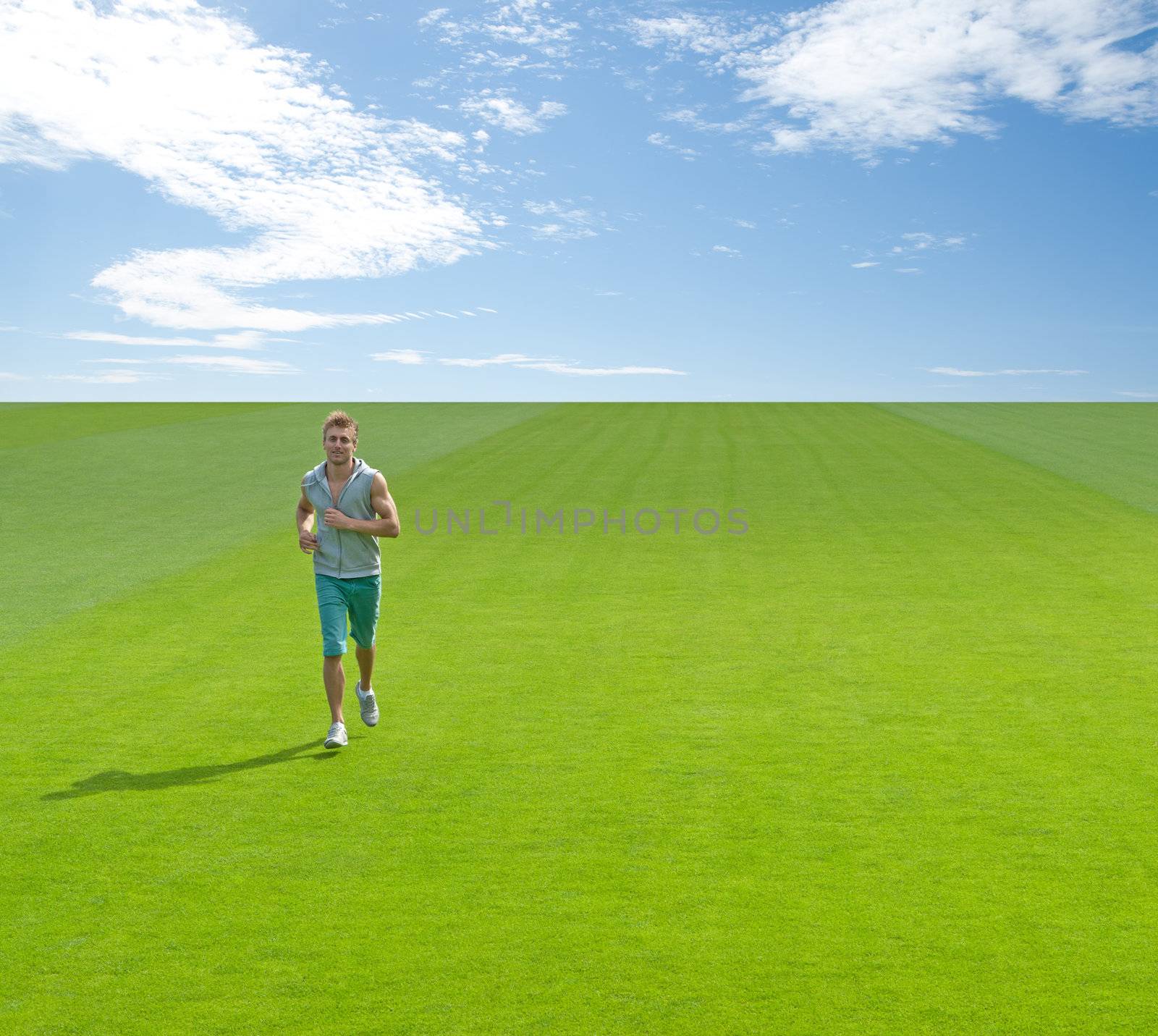 Sporty young man running on green field by anikasalsera