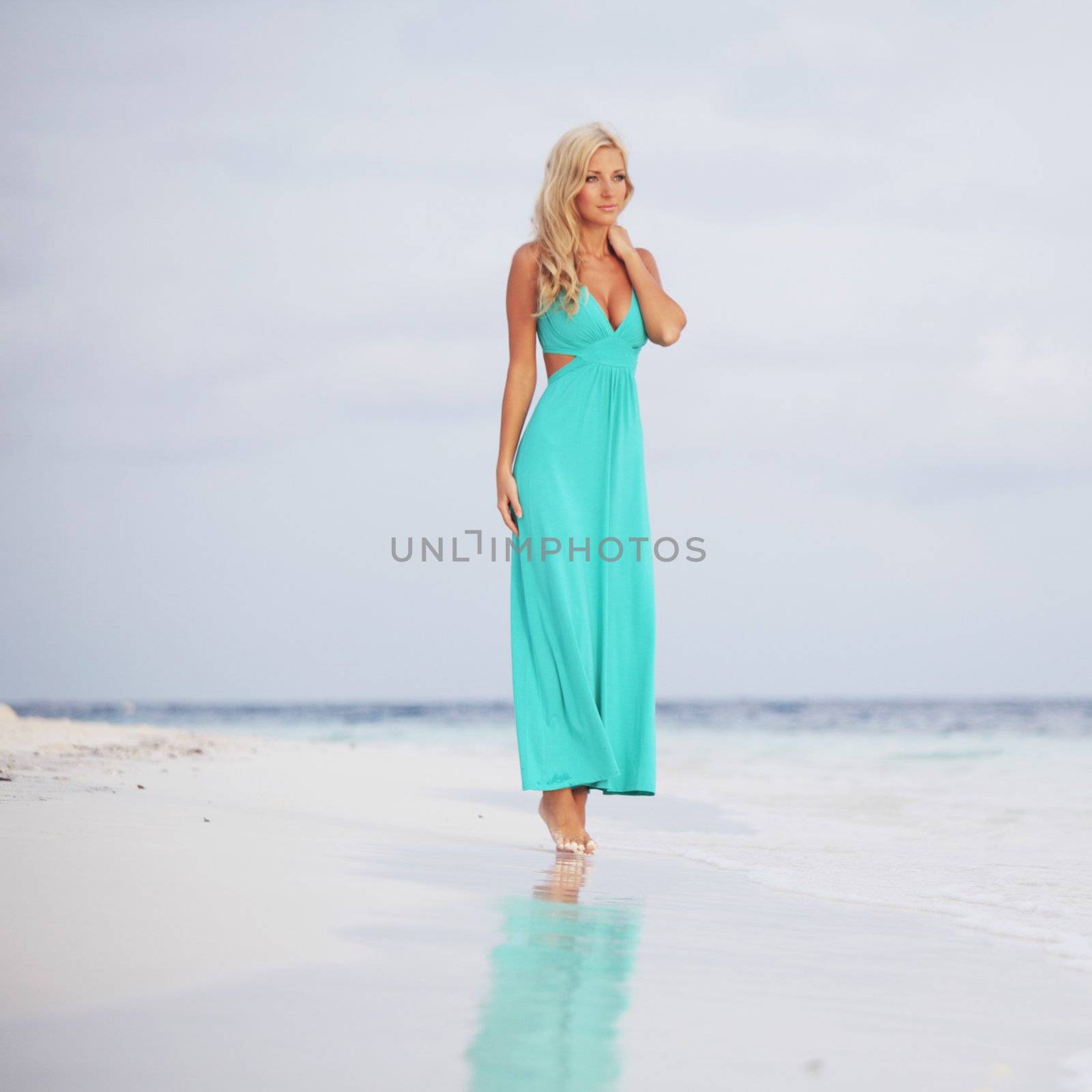 woman in a blue dress on the ocean coast