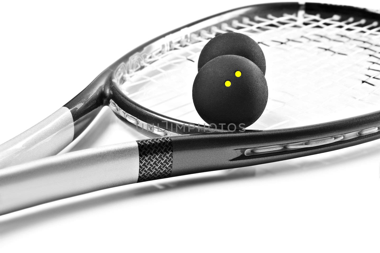 Close up of a black and silver squash racket and balls