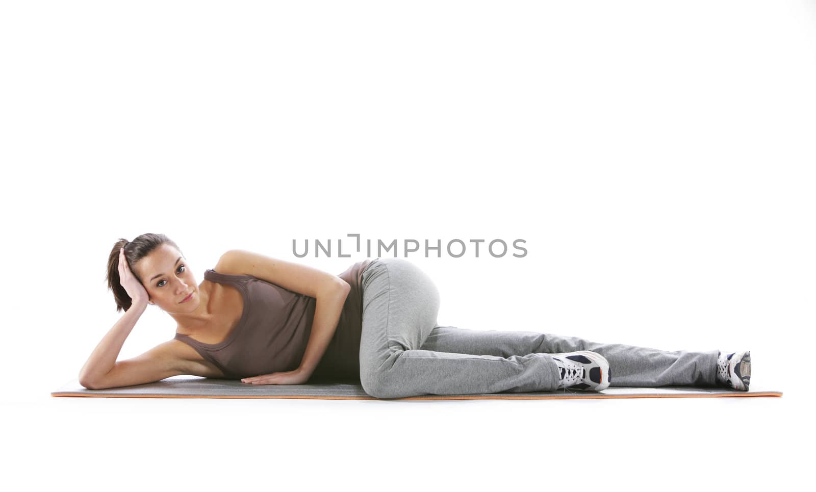 Fitness woman doing fitness exercise on mat . White background by stokkete